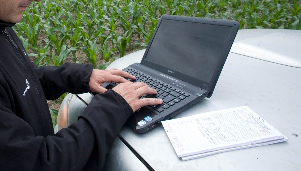 Productor con laptop en el campo